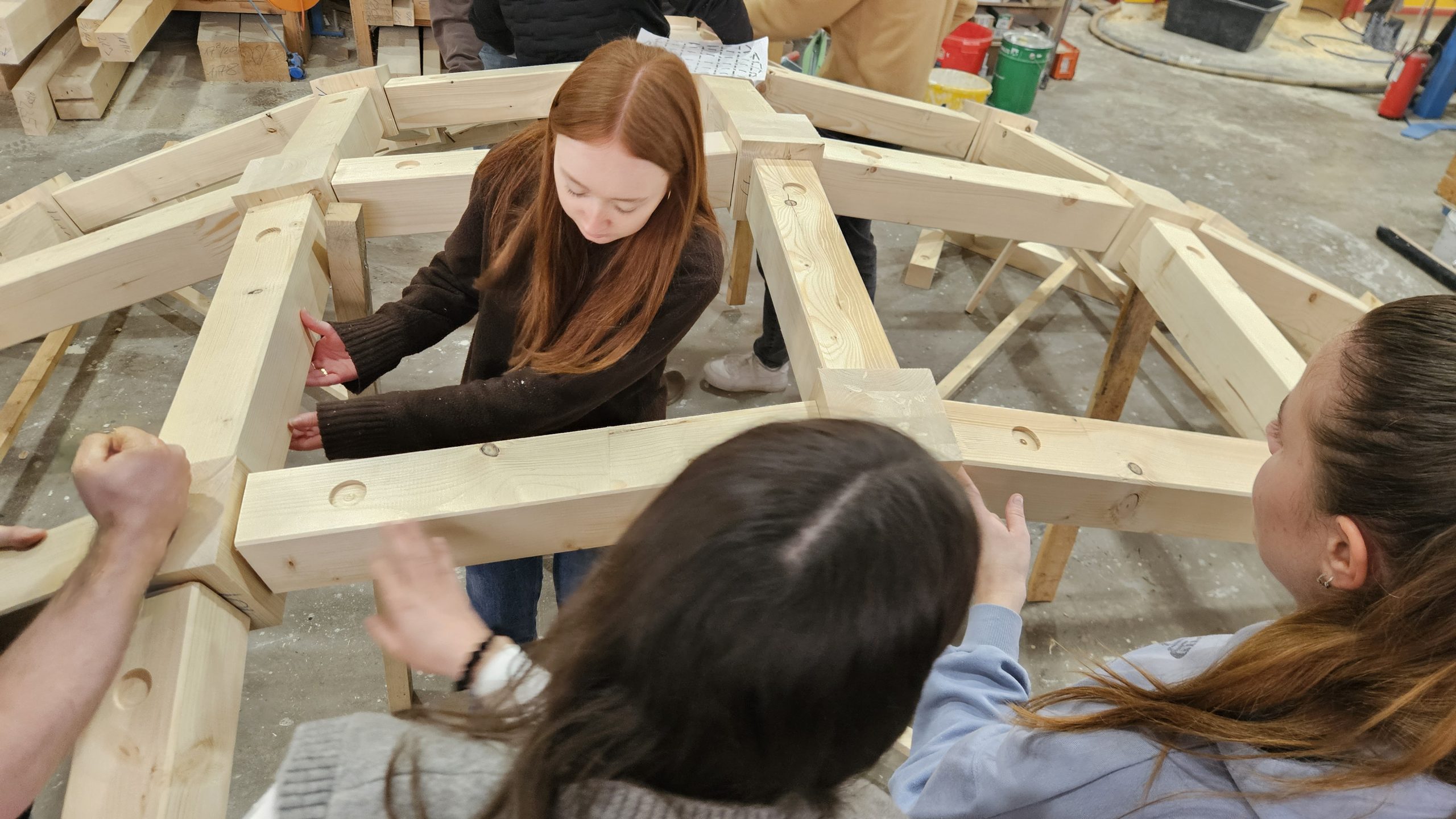 Zimmermann, der gerade einen Nagel einschlägt, auf einem Dach